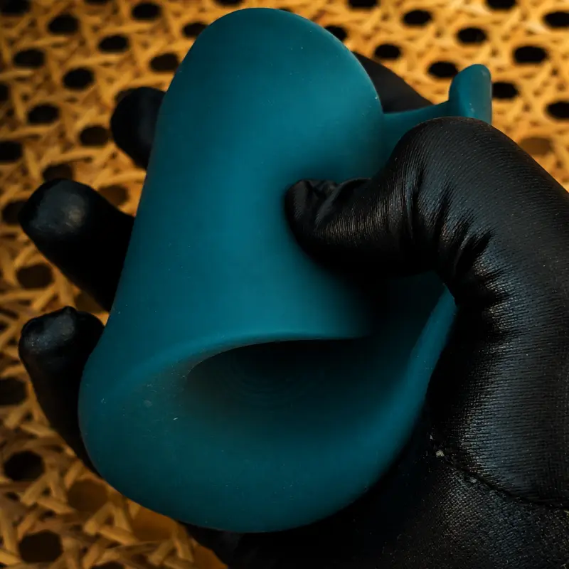 Holding the Lovense Gush 2 to show the open-flap vibrating male stroker shape