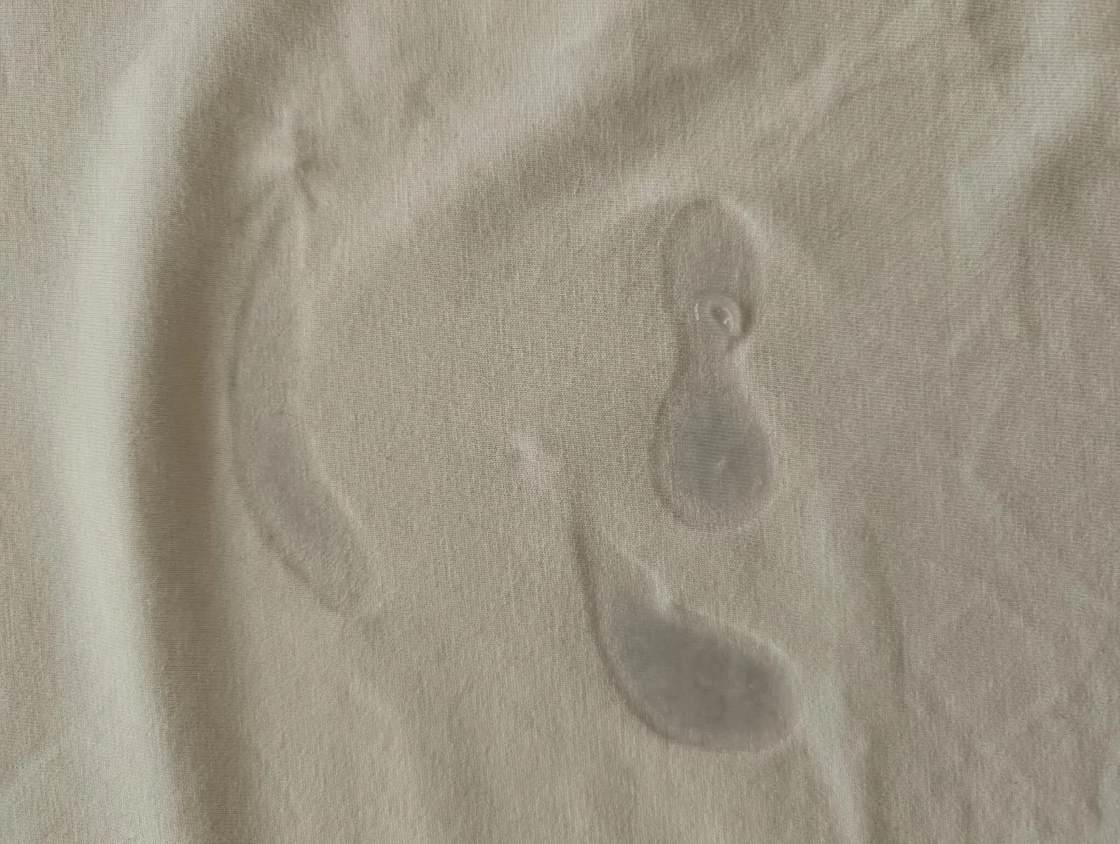 A white cotton t-shirt 12 hours after SPUNK Hybrid was applied: the lube has mostly soaked in, leaving faint dried outlines and one small glossy spot
